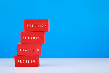 Trendy business or personal problem solving concept. Ladder made of red toy blocks with written words against blue background with copy spaceの写真素材