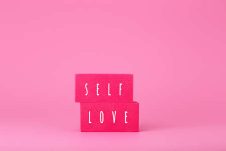 Self love minimal creative concept in pink colors against pink background with copy spaceの写真素材