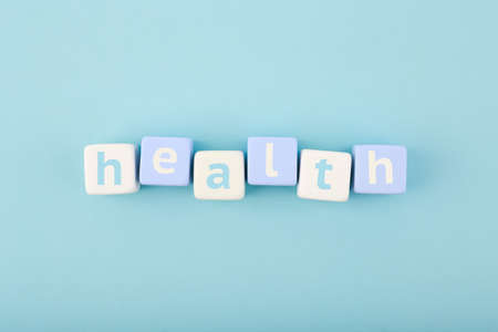 Health single word written on white and blue cubes in a row on bright blue background. Concept of mental and physical health, medications, life insurance or wellbeingの写真素材