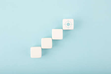 Ladder career, sales or business growth, success path or setting goal concept. White cubes as step stairs with target on bright blue backgroundの写真素材