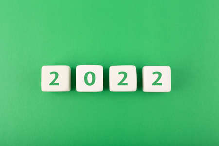2022 numbers on white cubes against green background. Minimal elegant business style concept of New Yearの写真素材