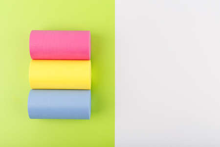 Flat lay with pansexual flag made of pink, yellow and blue rolls on light green and white background with copy space. Concept of pansexual community, sexual minorities, equal right and toleranceの写真素材