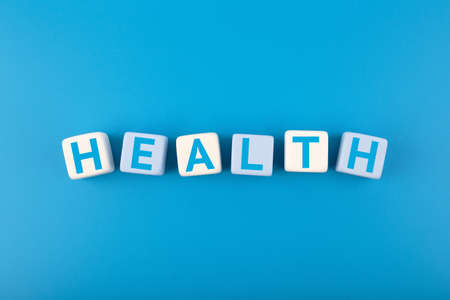 Health single word written on white and blue cubes in a row on dark blue background. Concept of mental and physical health, medications, life insurance or wellbeingの写真素材