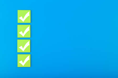 Four checkmarks on green tablets in a row on blue background with copy space. Concept of questionary, checklist, to do list, planning, business or verification. Modern minimal compositionの写真素材