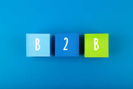 B2B minimal commercial marketing business concept. B2B letters written on multicolored cubes in a row against dark blue backgroundの写真素材