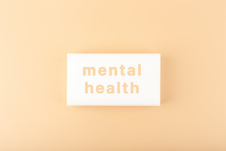 Mental health text written on white tablet on bright beige backgroundの写真素材