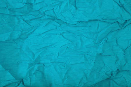 Aqua blue crumpled corrugated wrapping paper background with space for textの写真素材