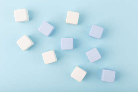 Simple creative flat lay with toy cubes spilled on bright blue background with copy spaceの写真素材