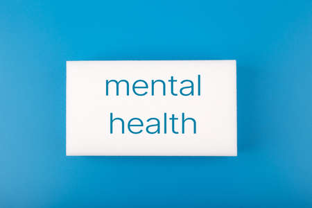 Mental health text written on white rectangle in the middle of dark blue backgroundの写真素材