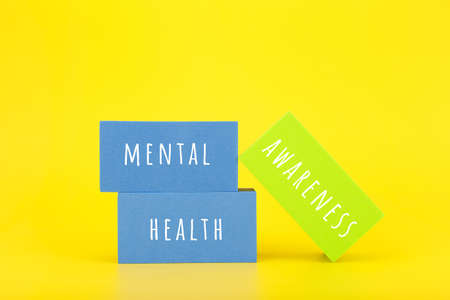 Mental health awareness concept on yellow background with text written on colorful rectangles. Concept of mental health, self care and psychological issuesの写真素材