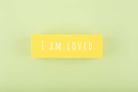 I am loved written on yellow rectangle in the middle of bright green backgroundの写真素材