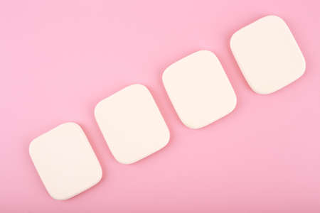 Close up of four make up sponges in diagonal row on bright pink backgroundの写真素材