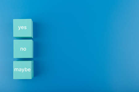 Yes, no and maybe written on blue toy cubes on blue background with copy space. Concept of positive and negative answerの写真素材