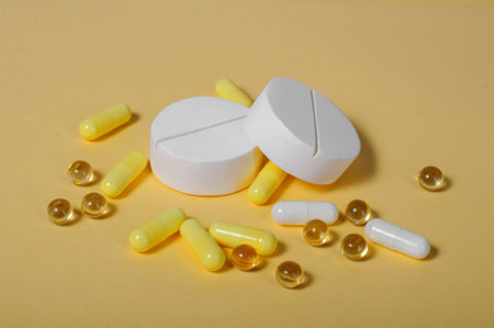 A bunch of big white and a lot of little yellow pills. On a yellow background