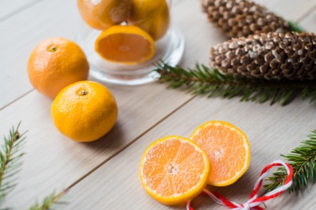 New Year Concept. Christmas decorations from fir-tree branches and the fruits of mandarin orange on wooden backgroundの写真素材