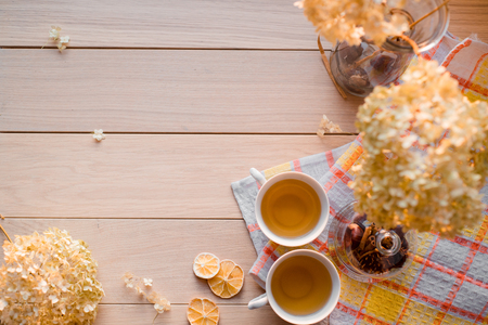 Autumn composition. Two mugs of hot tea on a linen yellow napkin. Dried hydrangea, lemon, chestnut, cinnamon.の写真素材