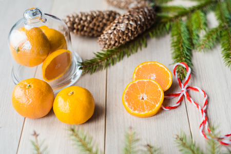 New Year Concept. Christmas decorations from fir-tree branches and the fruits of mandarin orange on wooden backgroundの写真素材