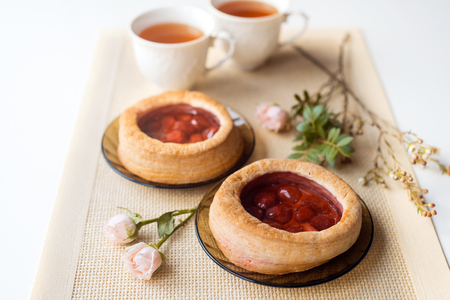 Morning tea with baked goods, rose flowers on the table. Cake with strawberries. On an rustic napkinの写真素材