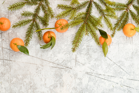 Christmas stone background with snow fir tree and tangerines.の写真素材