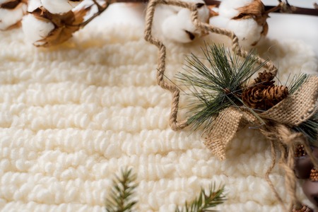 Christmas decorations, Christmas tree, knitted white scarf and cotton flowers on a white background.の写真素材