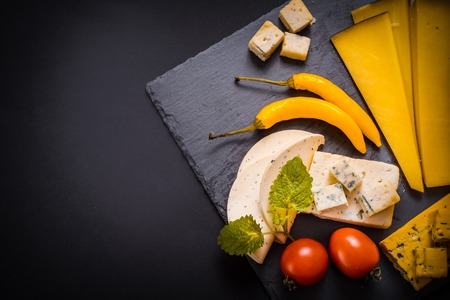 Variety of cheese, olives, prosciutto, over grey marble background, selective focus, yellow hot pepper, cherry tomatoes. There is a place for your inscriptionの写真素材