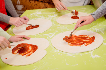 Preparation pizza with various ingredients in the cafe on the table