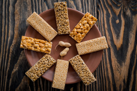 Kozinaki with seeds, nuts, sesame and honey. On a dark wooden background
