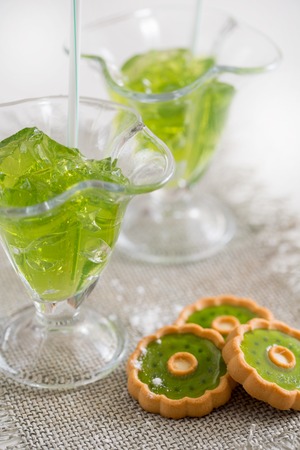tropical green cocktail with lemon and fresh mint, jelly with mint leaves in glass on a linen napkin on a white background.の写真素材