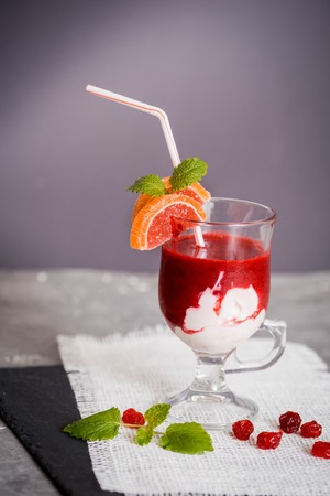 Fresh strawberry smoothie in a glass on the background. Berries of a cherry, fresh mint on a white napkin. Copy space, top viewの写真素材