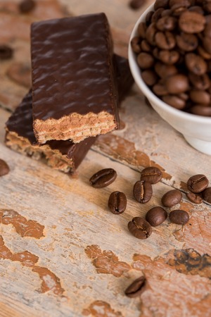 Cup of coffee with grains scattered on a wooden background. chocolate waffle, sweet dessertの写真素材