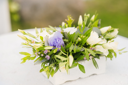 The wedding arch is decorated with blue flowers and white light silk. Summer wedding ceremony. Bridal bouquetの写真素材