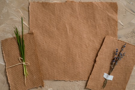 Notepad is a notebook for entries. Kraft paper postcard. Herbarium of dry grass of lavender flowers. On a gray brown antique backgroundの写真素材