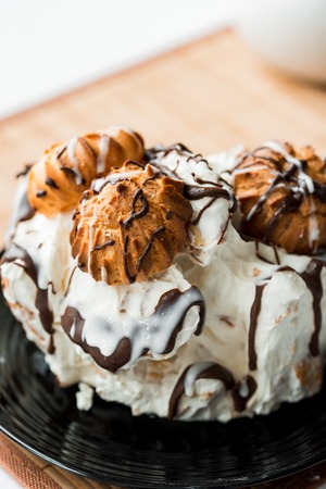 Chocolate cake with white chocolate syrup drizzled on top and layered carrot cake in background.の写真素材