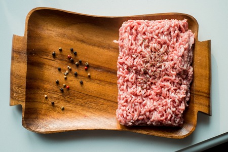 fresh minced meat with onions meat minced on a wooden tray. spices, salt and onions.の写真素材