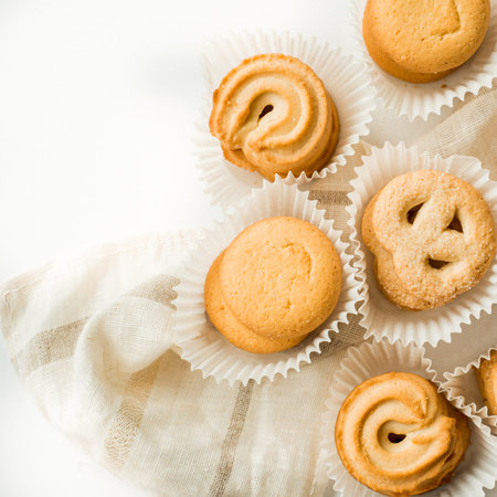 Set of different french cookies macaroons macaroons in a paper box. vanilla, set of different cookies in white paper corrugated packing on a table and linen antique napkinの写真素材