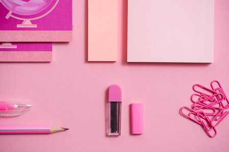 On pink background, school accessories and a pen, colored pencils, a pair of compasses, a pair of...