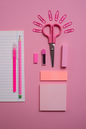 On pink background, school accessories and a pen, colored pencils, a pair of compasses, a pair of compasses, a pair of scissors. Copy space, top viewの写真素材