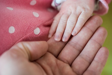 Newborn baby, closeup of fingers of fingers on hand of mother offering him love and securityの写真素材