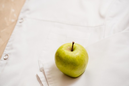 an apple lies on a white medical dressing gown.の写真素材