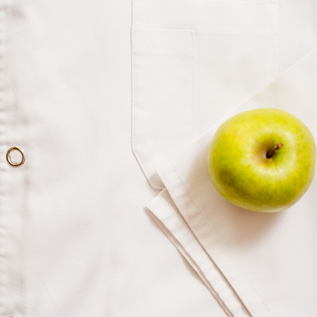 an apple lies on a white medical dressing gown.の写真素材