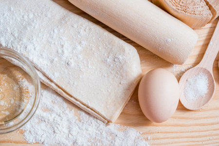 cooking dough, flour and eggs on a wooden table.