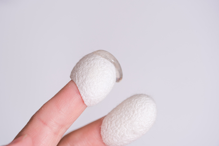 silkworm cocoon on finger with medical cream, cosmetology and skin procedures. Beauty salon and spa concept.の写真素材