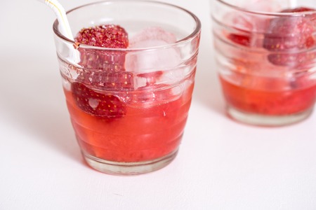 Red drink with ice, mint leaves and strawberry cherry. Cocktail making bar toolsの写真素材