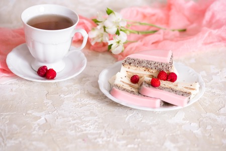 A sweet pink rose cup cake with tea pot and cup on the table on a light background, copy spaceの写真素材