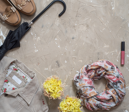 Women's autumn clothes. Autumn female outfit. Set of bag, accessories - shoes and scarf on wooden brown table background. Top view, copy space.の写真素材