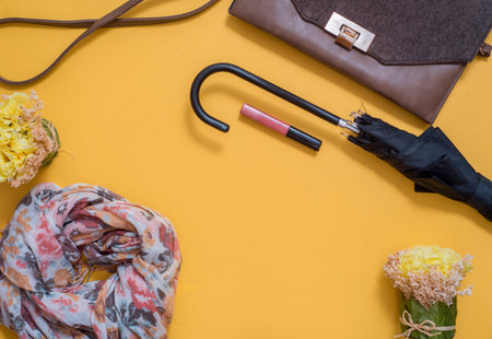 Gray with silvery female sneakers, scarf and bag on a bright yellow background. Autumn Fashion...
