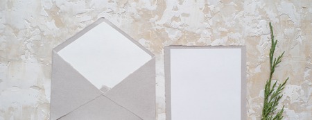 Top view banner of envelope and blank greeting card with rose flowers on white wooden backgroundの写真素材