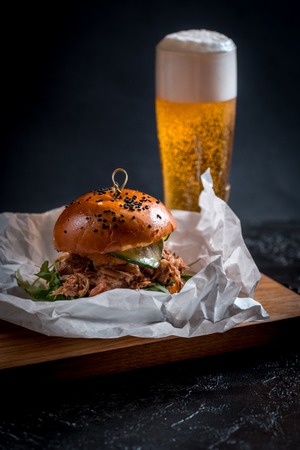 Hamburger and dark beer in vintage wooden table.の写真素材