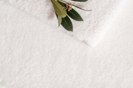 Spa composition on white table. white fluffy bath towels with eucalyptus branch. The concept of health, cleanliness and spa. Copy spaceの写真素材