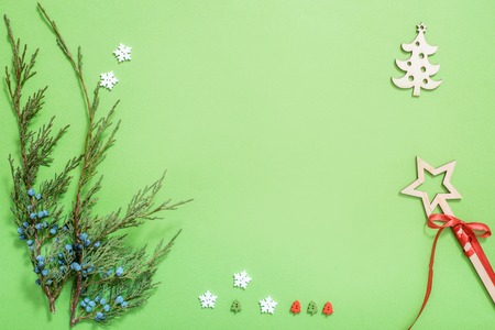 Christmas Kraft greeting card, fir branches, a star with a red ribbon, wooden fir trees, sweet wafer rolls.の写真素材
